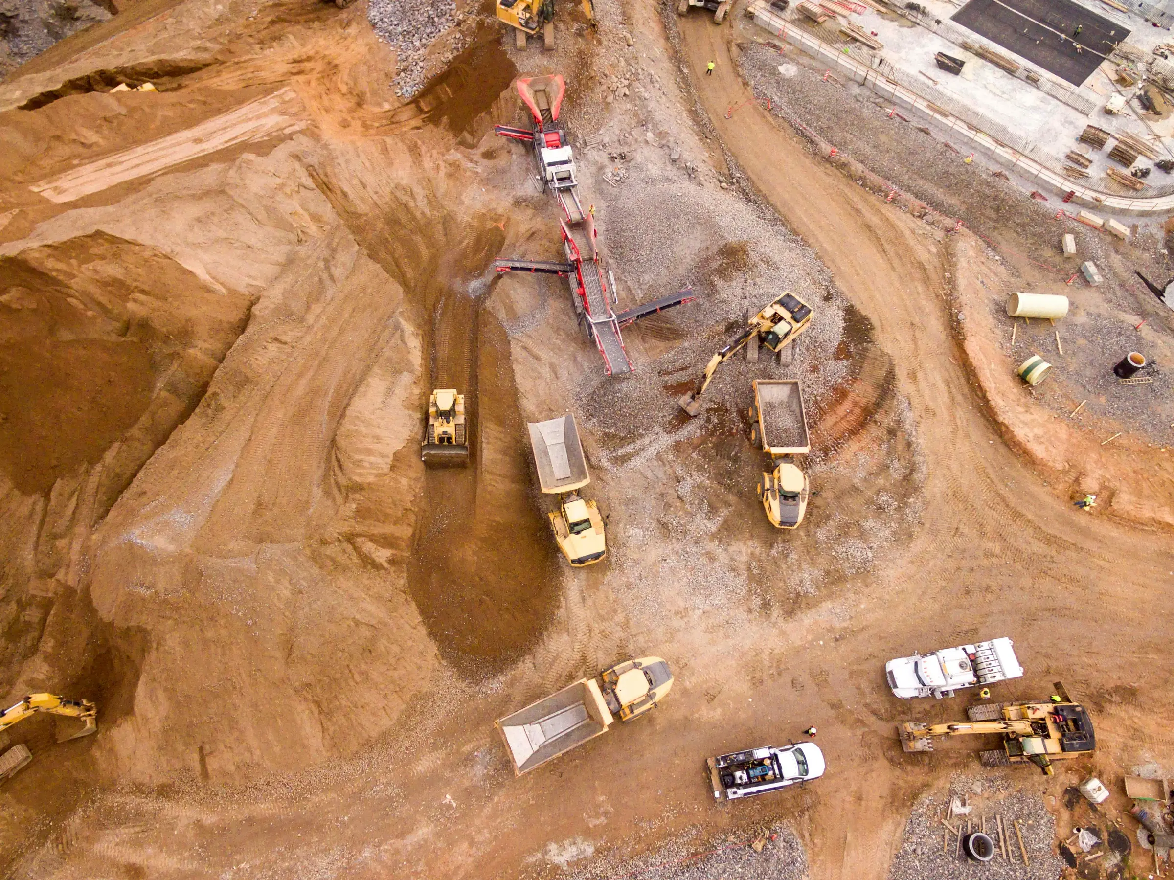 Aerial view of a construction site with several excavators and dumpers